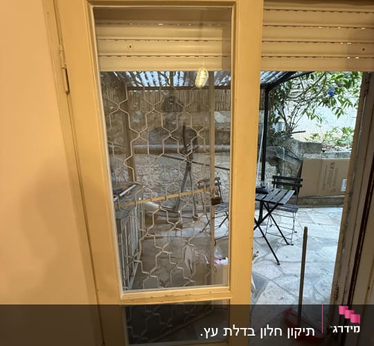 דלת זכוכית עם סורג מתכת בחצר